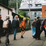 Photo of members of Sydney Cohousing walking together across an alleyway entering housing co-op on tour
