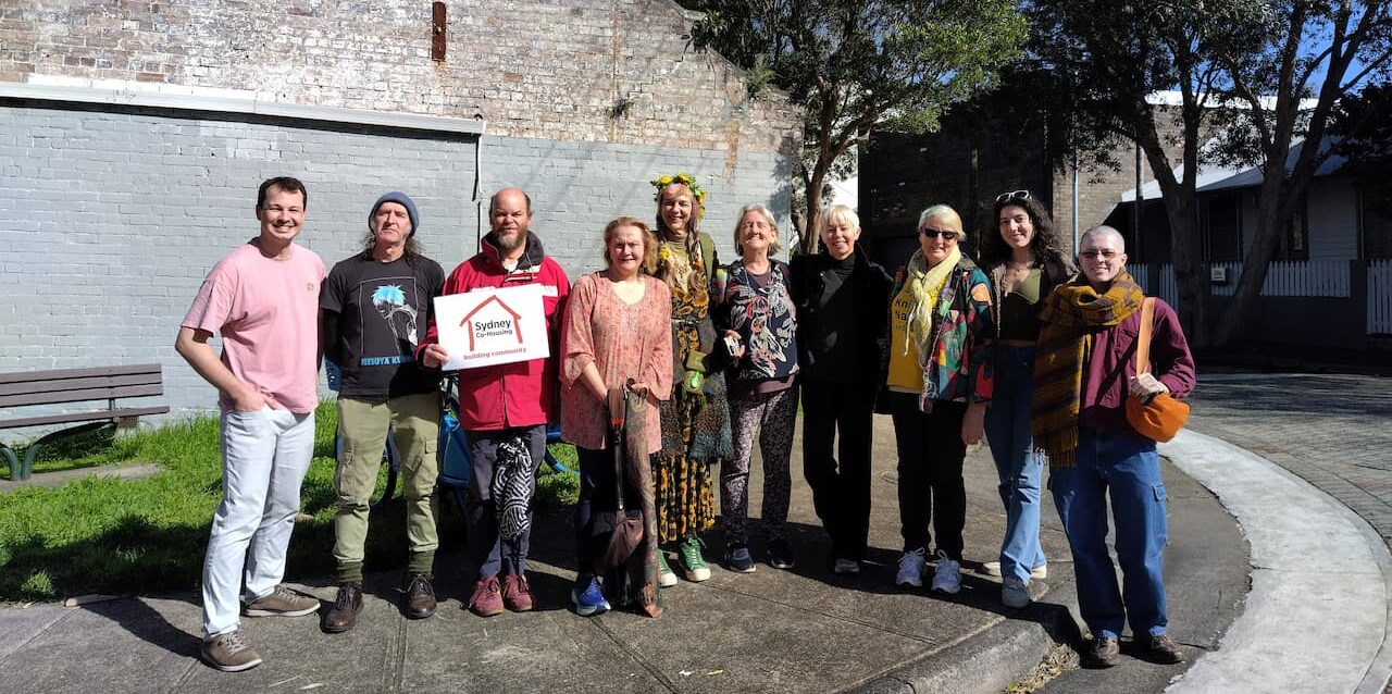 Sydney Cohousing members about to go on a tour of a co-op, standing smiling at camera